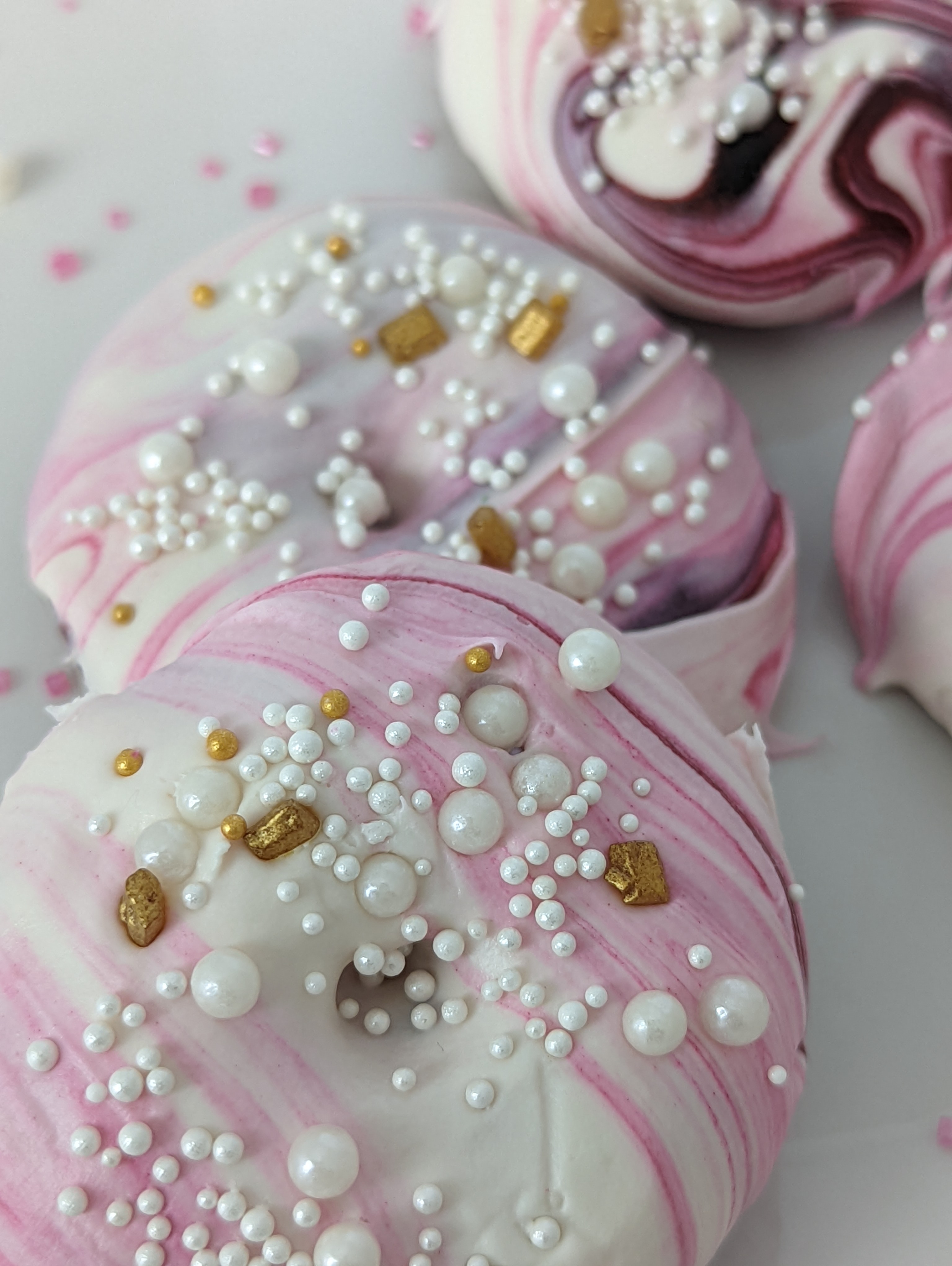 Swirl donuts with various sizes of pearls and gold rocks.